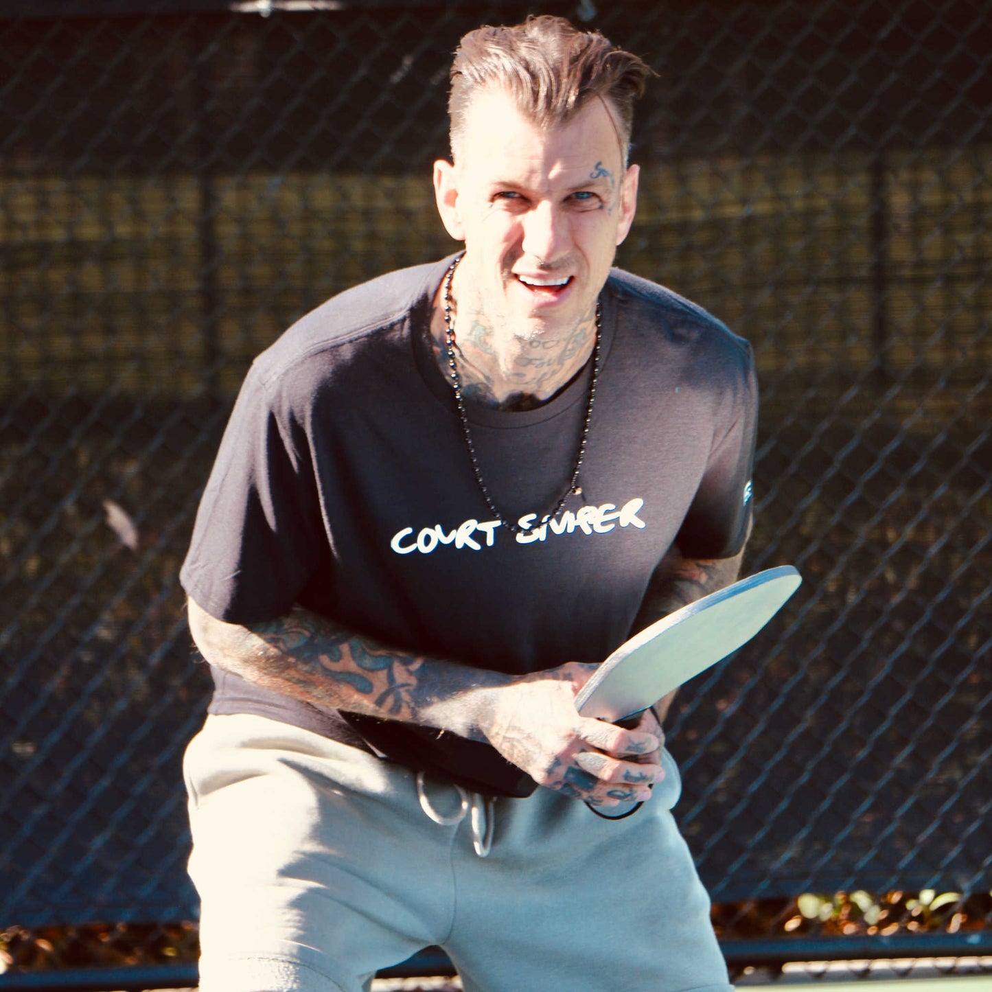 Player wearing court sniper performance shirt by Soul Bandit Pickleball holding racket