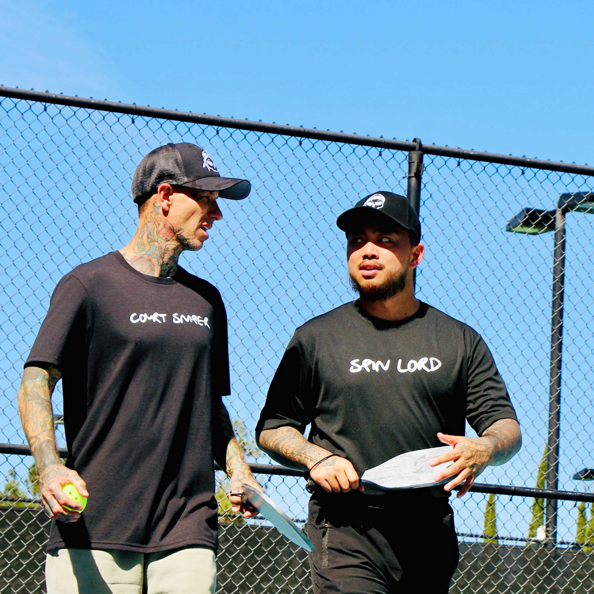 Two guys on court wearing apparel from Soul Bandit Pickleball including the Court Sniper performance shirt