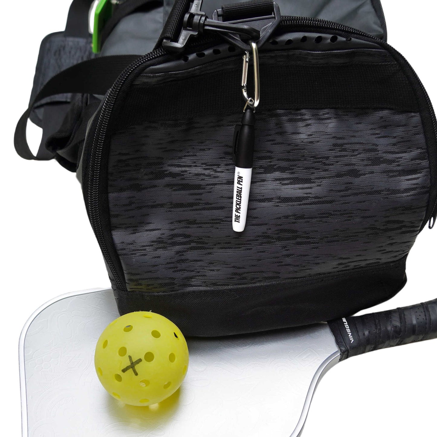 Pickleball Pen Marker attached to clip hanging on a pickleball bag shwoing X  marked on a pickleball